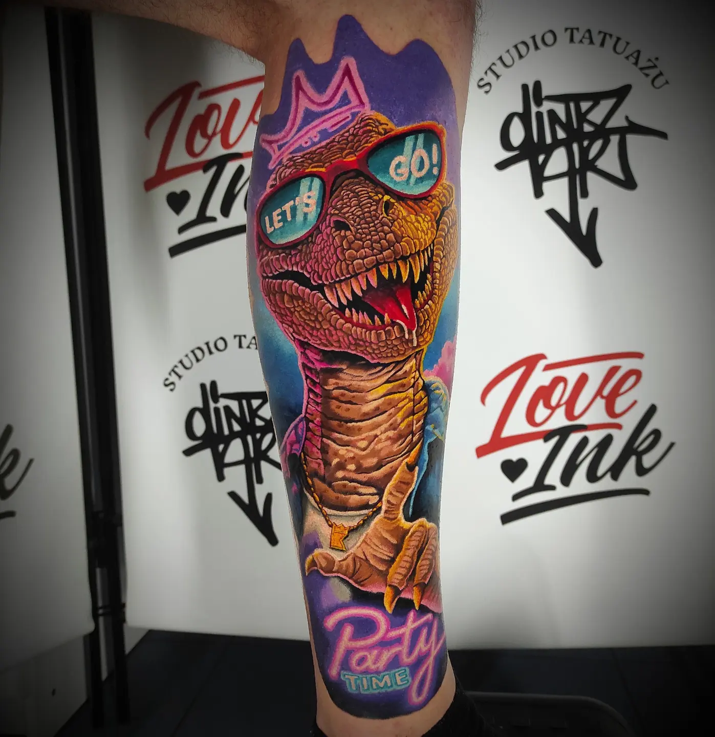 Kolorowy tatuaż imprezowego dinozaura